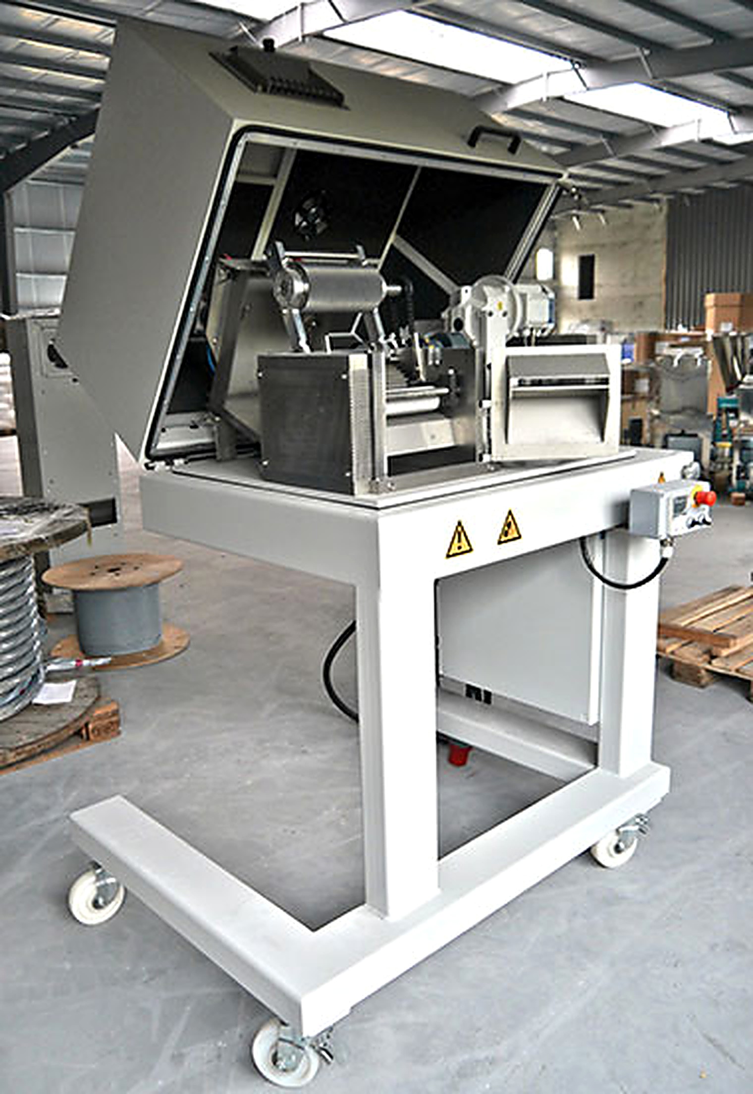 Geöffneter Granulator mit Einzugswalzen und Schneidrotor auf fahrbarem Gestell in der Fertigungshalle.