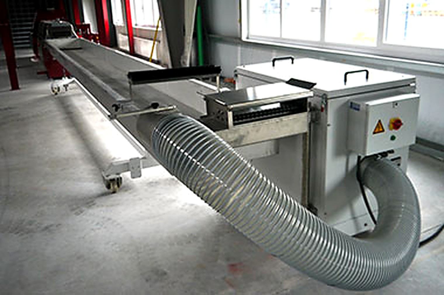 Wasserbad der Stranggranulierung aus Edelstahl mit anschließendem Granulator und Absaugschlauch.